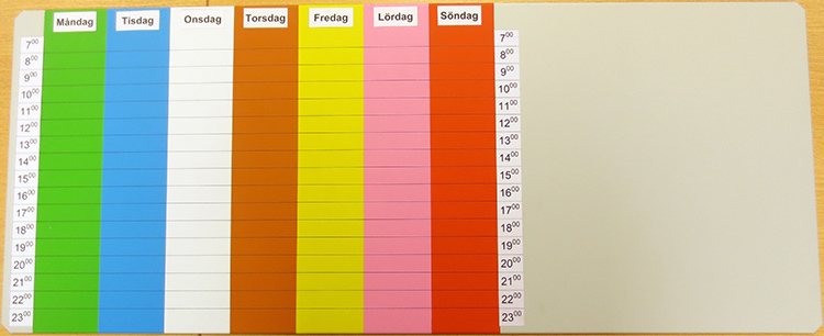 Magnettavla med kolumner för veckans dagar i olika färger, indelad i timmar, och en tom yta på tavlan