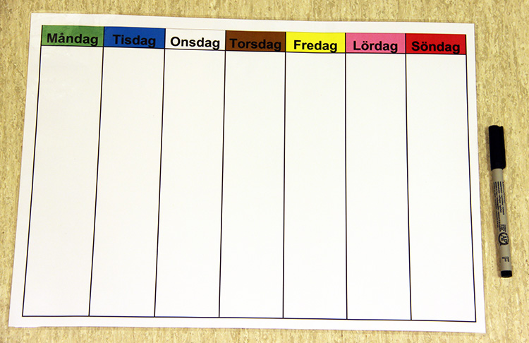 Veckoschema med dagarnas namn i olika färger, och en penna