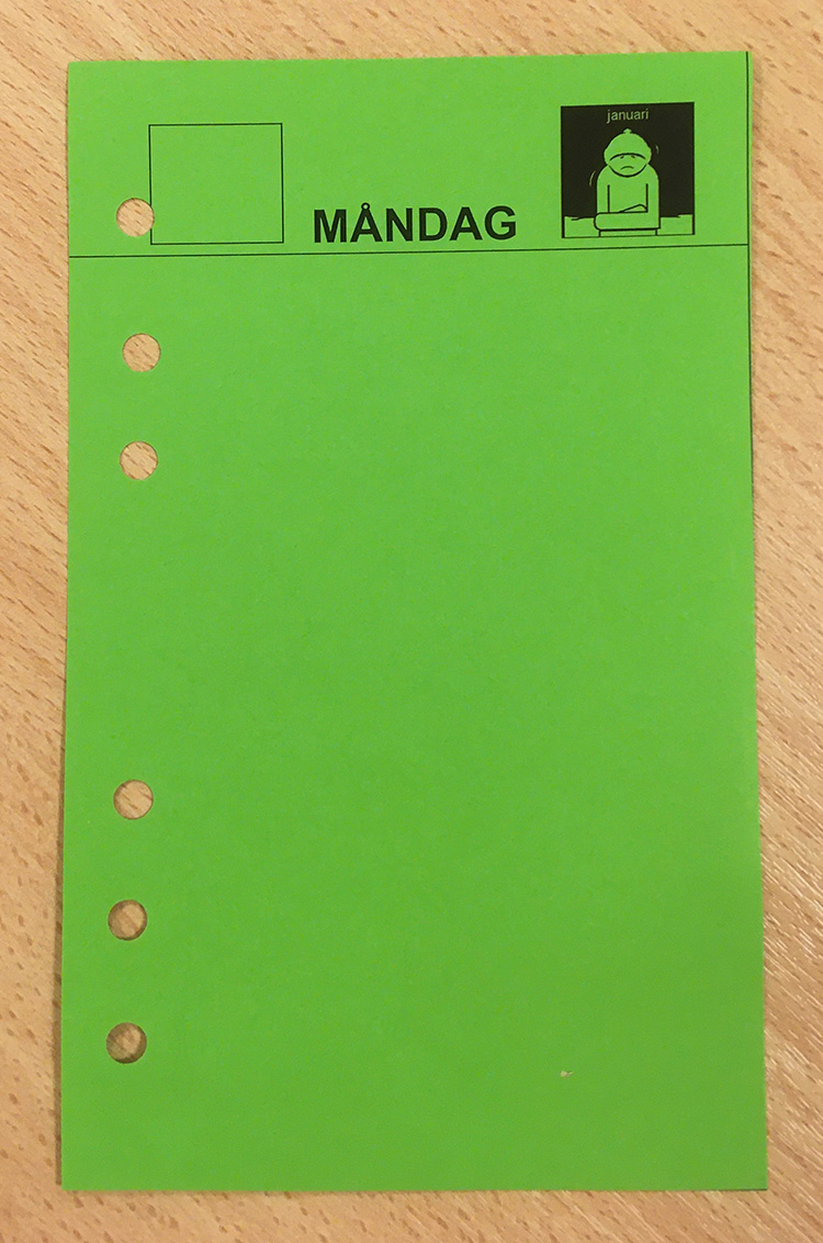 Grönt Filofaxblad med sex hål i, och ordet måndag, en liten pictogrambild och en tom ruta på