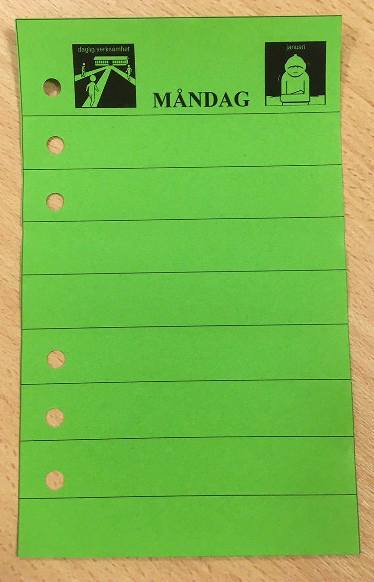 Grönt, linjerat Filofaxblad med sex hål i, och ordet måndag och två små pictogram på