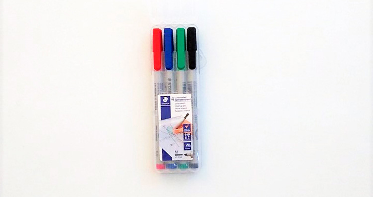 Förpackning med fyra pennor i färgerna rött, blått, grönt och svart.